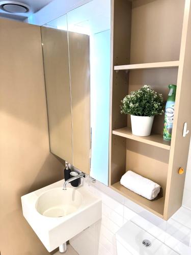 a bathroom with a sink and a mirror at ADEK Apartments Melb Central-Modern City Escape in Melbourne
