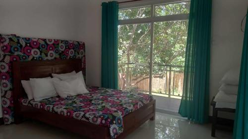 une chambre avec un lit et une grande fenêtre dans l'établissement Vista Linda Farmstaycation, à Alitagtag