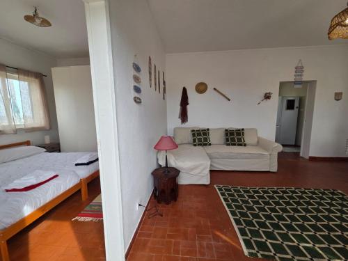 a living room with two beds and a couch at Casita do avô in Carvoeira