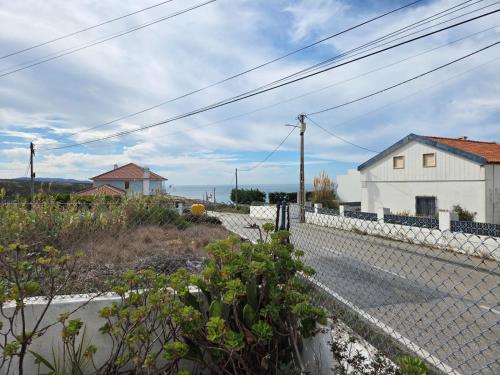 a white fence in front of a white house at Casita do avô in Carvoeira