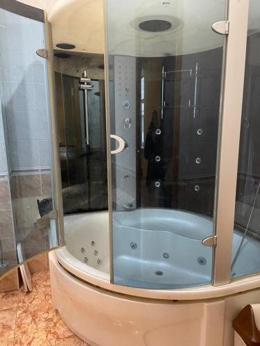 Una ducha con bañera azul en un baño. en Good Dreams Mini Otel, en Kiev