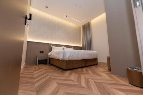 a bedroom with a bed and a wooden floor at فندق نخبة العارض in Riyadh