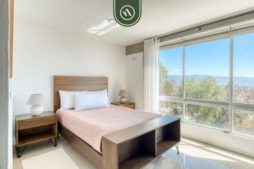 a bedroom with a bed and a large window at 3 BR Condo - Panoramic Views - 5 Min to Downtown in Oaxaca City
