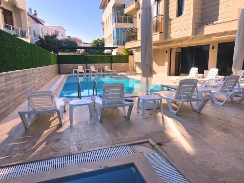 a swimming pool with lounge chairs and a table and a swimming pool at La Vita Es Bella in Antalya