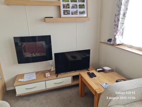 Lytchett MinsterにあるWillerby Escapesのテレビとコーヒーテーブルのあるリビングルーム