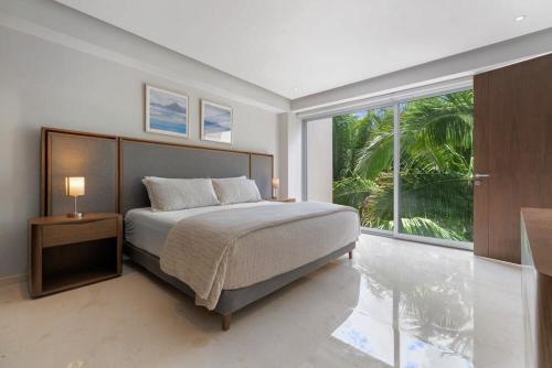 a bedroom with a bed and a large window at Amazing Condo - Beach Access - Spa - Pool in Higuera Blanca