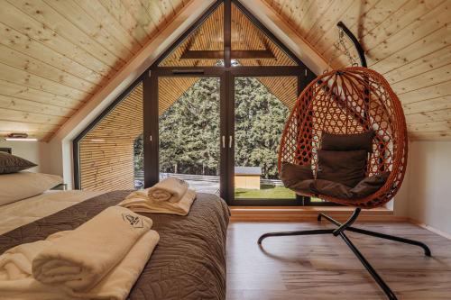Una habitación con una hamaca en una casa con ventana. en Honey House Wierchy- prywatna strefa SPA, en Jaszczurowa