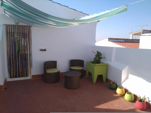 un patio con 2 taburetes, mesa y sillas en Hostel Raymundo, en Évora