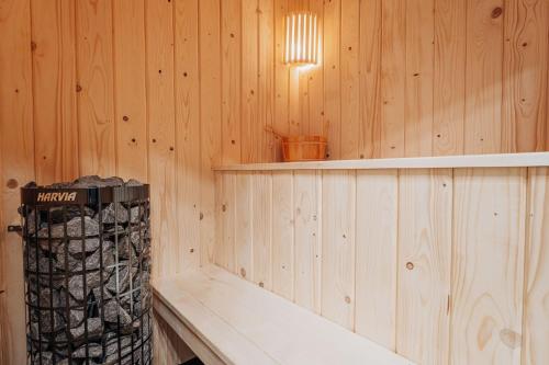 a room with a wooden wall with a tub and a light at Honey House Wierchy- prywatna strefa SPA in Jaszczurowa