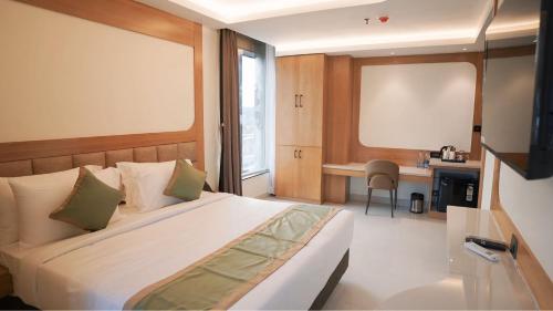 a bedroom with a bed and a desk in it at Hotel Green View in Baharampur