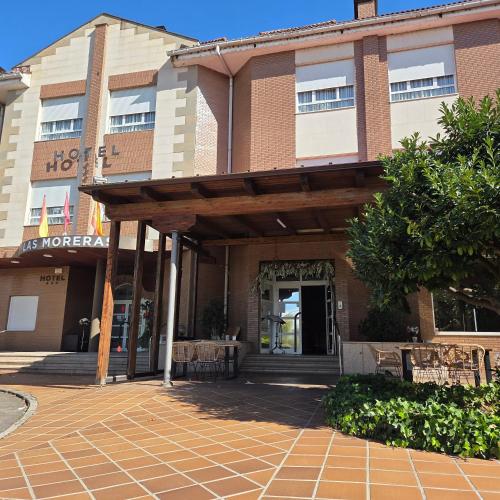 ein Gebäude mit einer Veranda und einem Tisch davor in der Unterkunft Hotel Las Moreras in León
