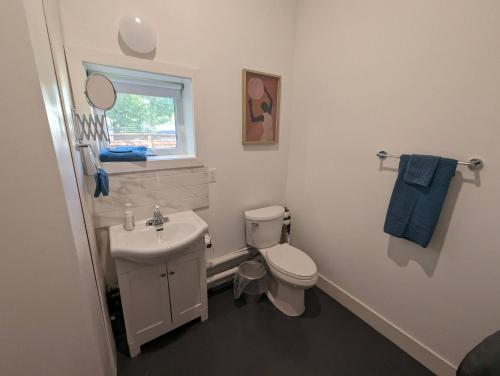 a white bathroom with a toilet and a sink at Atlantic Oasis in Halifax