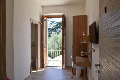 Camera con scrivania e porta di accesso a un balcone. di La Piazzetta Affittacamere a Ghilarza