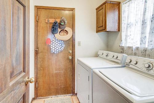 a kitchen with a washing machine and a wooden door at Hiking Nearby! Mountain-View Home Outside ABQ in Edgewood