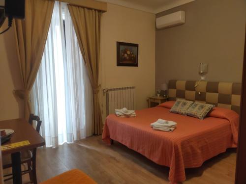 a hotel room with a bed and a window at Bed & Breakfast Hostel H24 in Ragusa