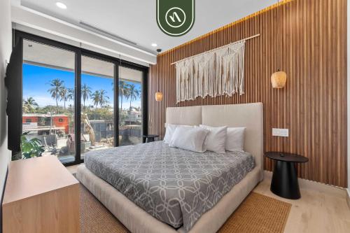 a bedroom with a bed and a large window at Luxury 2 BR Condo with Dream Pools - Beach - Art in Bucerías
