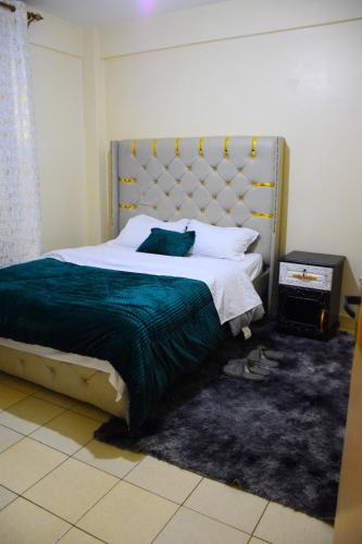 een slaapkamer met een groot bed met een groot hoofdeinde bij Secure, modern 1 bedroom at juja in Juja