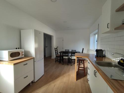 a kitchen and dining room with a table with a microwave at Casa da Nogueira in Paredes de Coura