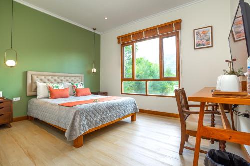 Un dormitorio con una cama y un escritorio y una ventana. en Suan Pa Khao Lom Homestay, 