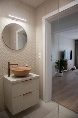 a bathroom with a bowl sink and a mirror at Nad Jeziorem in Rożnów