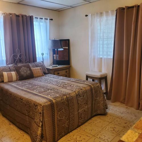 une chambre avec un lit, une table et des fenêtres dans l'établissement cozy corner with pool minutes away from the beach, à La Paz