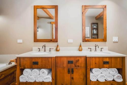 un bagno con due lavandini, due specchi e asciugamani di Monthly or Seasonal Large Petite Lake 44 Lakehouse Retreat with Private Pier and Hot Tub secluded Deep in the Woods a Fox Lake