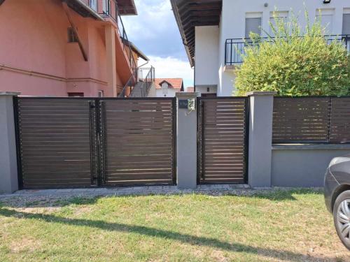 una puerta en una valla delante de una casa en Apartman Telep Novi Sad Retreat Balcony Garden Free Parking, en Novi Sad