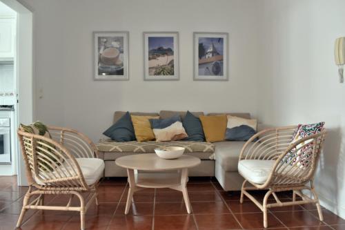 a living room with a couch and two chairs and a table at Abrigo das Matas in Porto Santo