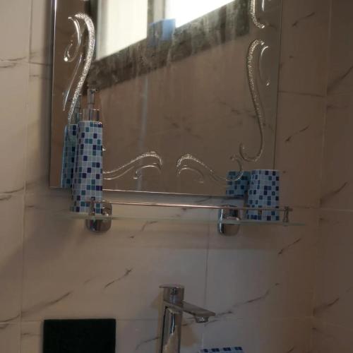 a bathroom with a mirror and a sink and a mirror at Chambre SCAT urbam in Dakar
