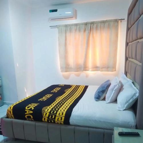 a bed in a room with a window and a bedspread at Chambre SCAT urbam in Dakar