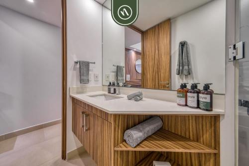 ein Badezimmer mit Waschbecken und Spiegel in der Unterkunft Brand New 1 BR Condo - Pool - Jacuzzi - Gym in Nuevo Nayarit