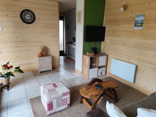 una sala de estar con un sofá y una mesa en Gîte ambiance Chalet, en LʼEstrade