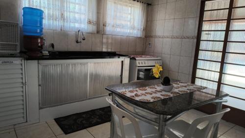 a kitchen with a table with chairs and a stove at Chácara charmosa com piscina, campo de futebol in Guaratinguetá