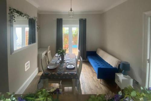 a living room with a table and a blue couch at Seaview 2 Bedroom House Sleeps 4 - Pets Ok -WiFi in Shoreham-by-Sea