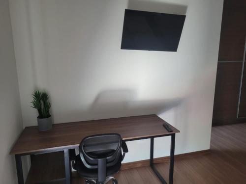 a desk with a black chair in a room at new apartment in Cochabamba