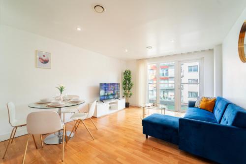 a living room with a blue couch and a table at Cozy 2BR Apt in Greenwich, Near O2 Arena and Excel, Fast Wi-Fi, Free Parking, Excellent links Elizabeth and Southeastern Line in London