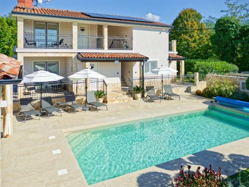 a house with a swimming pool in front of a house at Villa Morgan by Rent Istria in Umag