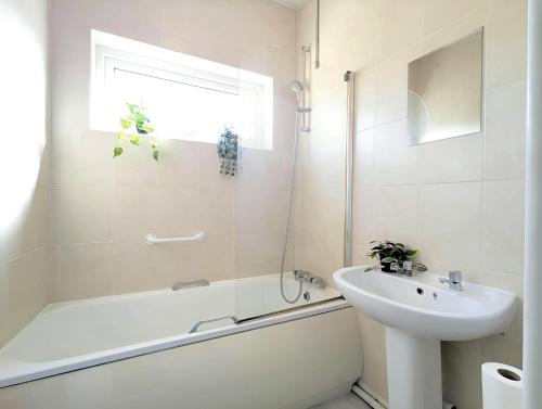 ein weißes Badezimmer mit einem Waschbecken, einer Badewanne und einem Waschbecken in der Unterkunft Charming 3-bed Home Near Centre Free Parking in York