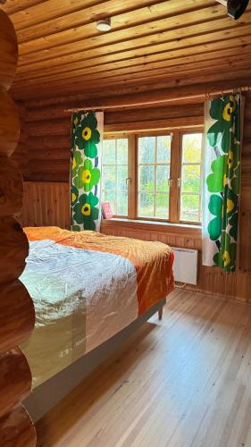 a bedroom with a bed in a log cabin at Hännänpää - TailTip Unique Log House in Vihti