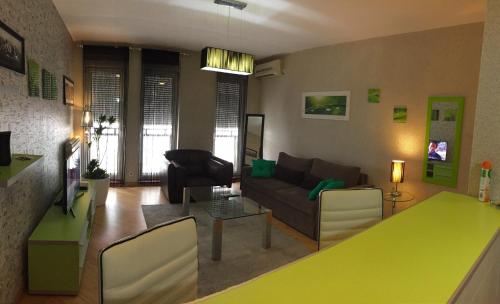 a living room with a green table and a couch at Vip apartment Beograd in Belgrade