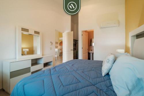une chambre avec un lit bleu et un miroir dans l'établissement 2BR Condo in Acapulco with Private Patio - Pool, à Acapulco