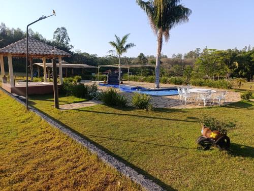 a park with a picnic table and a palm tree at Chácara Recanto Dona Celeida in Goiás