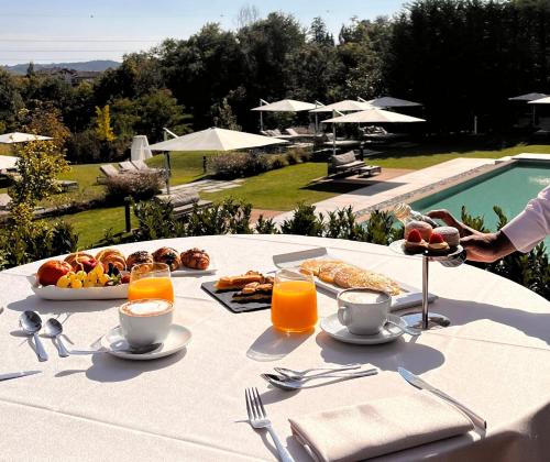 a white table with food and drinks and a pool at Relais & Spa Castello di Casiglio in Erba