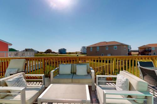 a patio with two chairs and a table on a deck at Seas the Day in Port Aransas