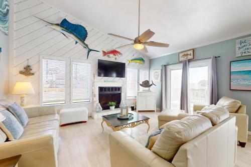 a living room with white furniture and a ceiling fan at Seas the Day in Port Aransas