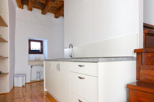 una cocina con armarios blancos y fregadero en Holiday home Castelier en Vodnjan