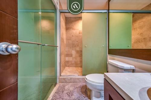 a bathroom with a toilet and a glass shower at Amazing 2BR Condo with Pool and Access to VIDANTA in Jarretadera
