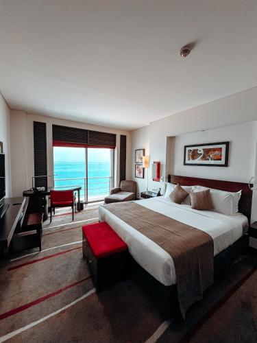 a hotel room with a large bed and a piano at Sofitel Al Khobar The Corniche in Al Khobar