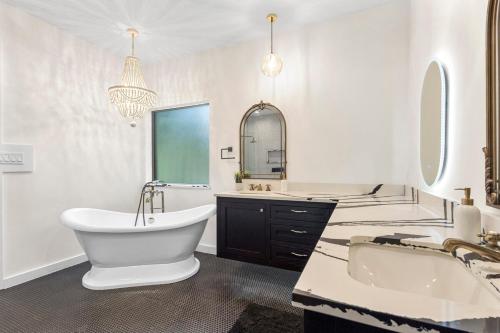 a white bathroom with a tub and a sink and a bath tub at Luxe House Houston in Houston