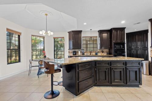 a large kitchen with wooden cabinets and a large island at Luxe House Houston in Houston